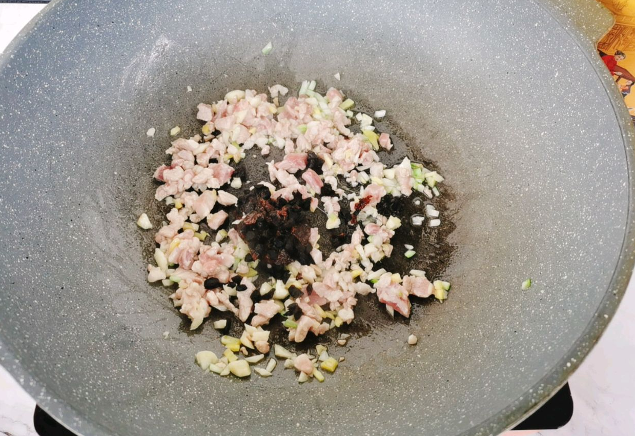 Cook minced pork until color changes, then add doubanjiang and fermented black beans. Stir well.