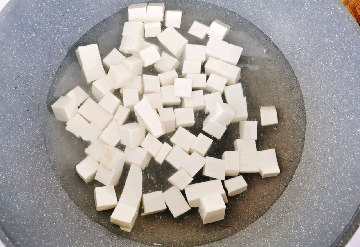 Boil tofu in salted water for 30 seconds to remove moisture and beany taste.