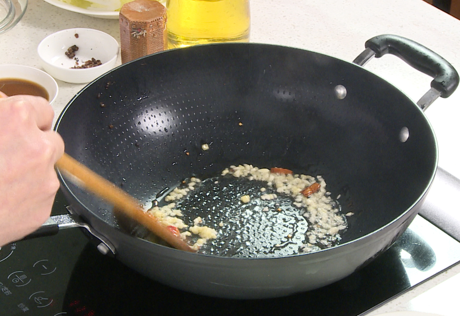 Saute dried chilies in infused oil, then add garlic and ginger for fragrant aromatics.