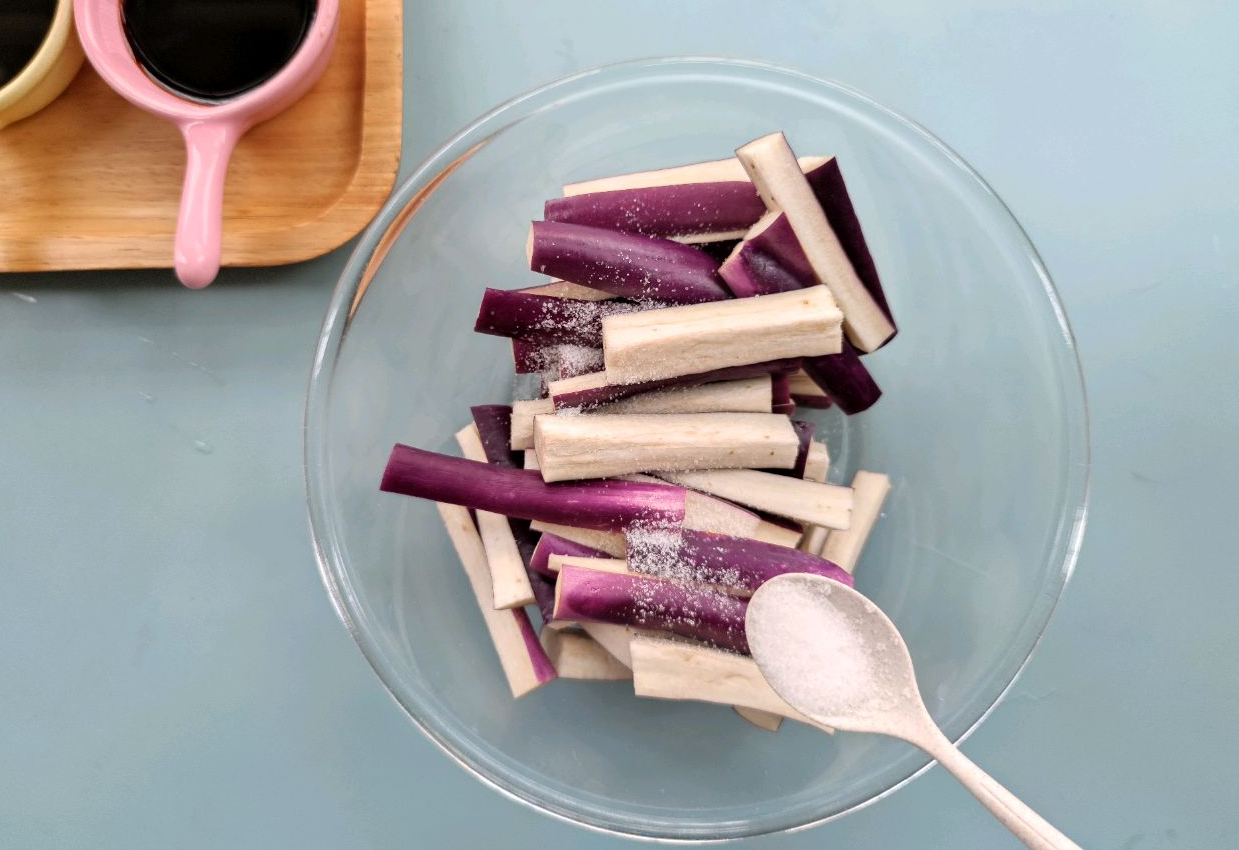 Prepare eggplant strips by salting them to release moisture, then rinsing and squeezing out water.