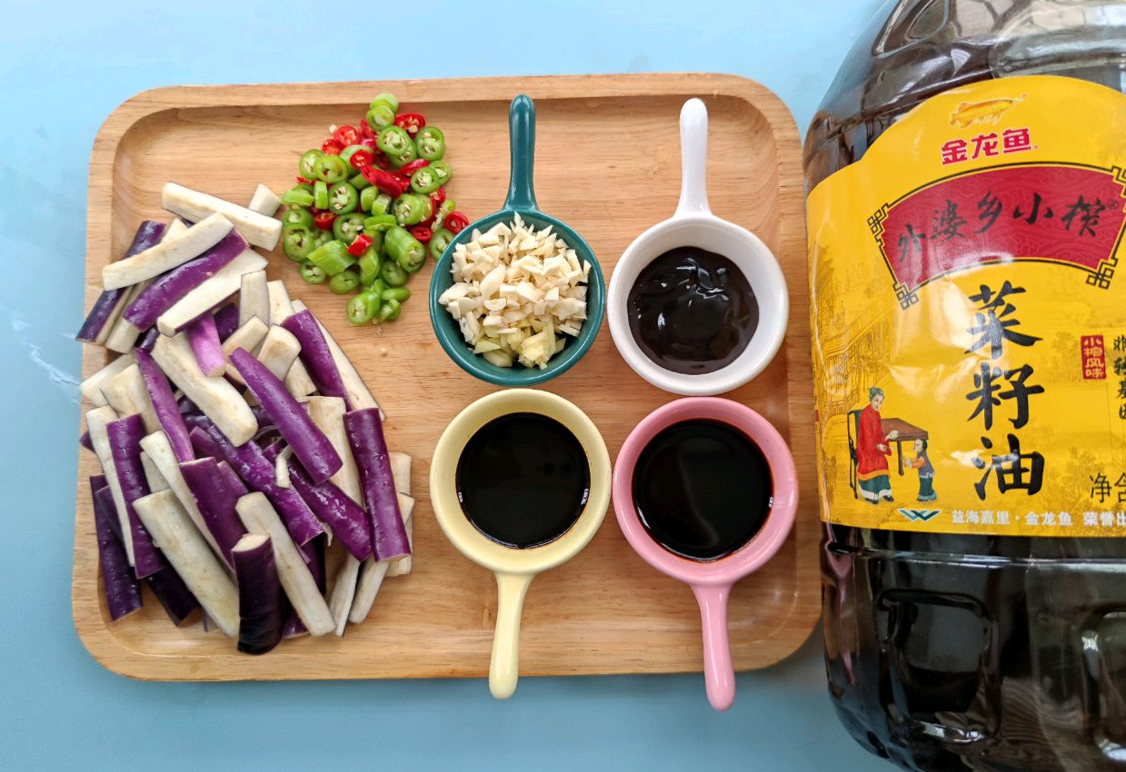 Prepare eggplant, chili peppers, ginger, and garlic for cooking.