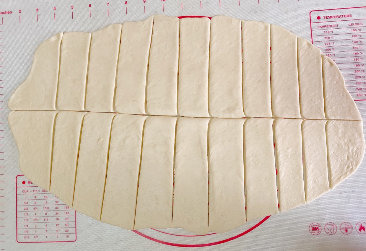 Cut dough into uniform strips. Brush with oil if sticky.