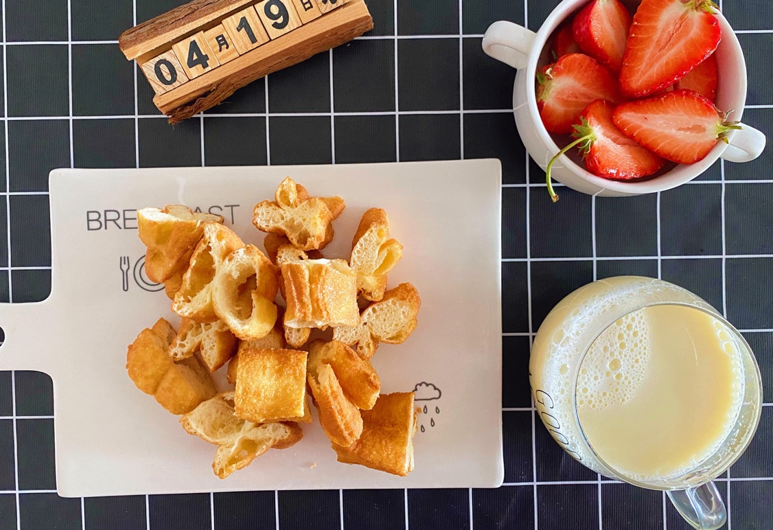 Instructions for serving fried donut sticks: cut into pieces, serve on a plate, pair with soy milk.