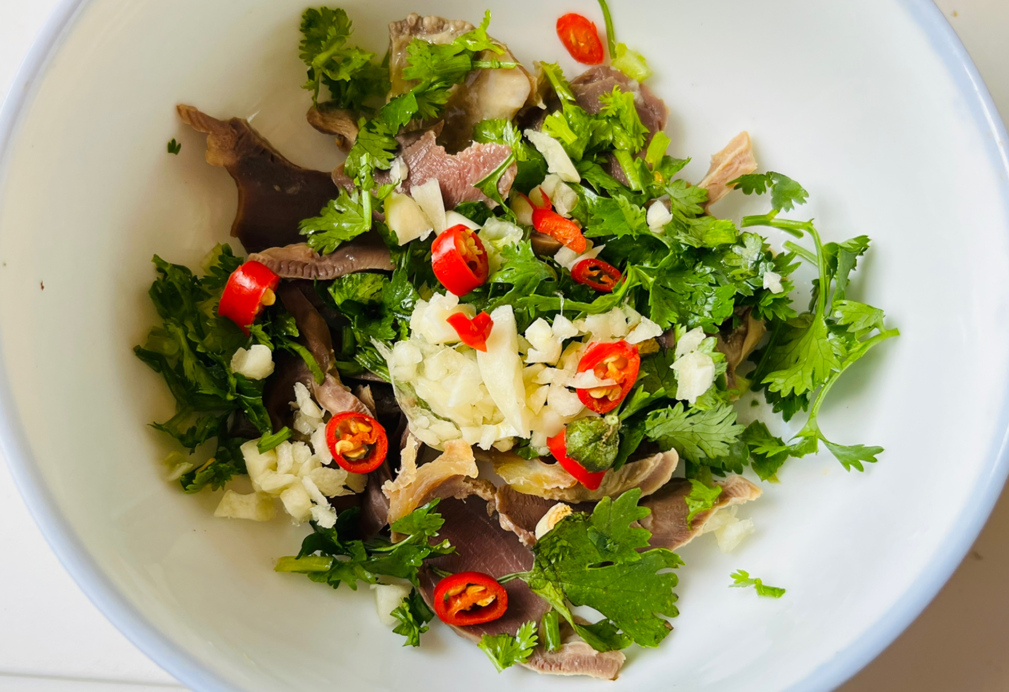 Add garlic, chili peppers, and cilantro to chicken gizzards.