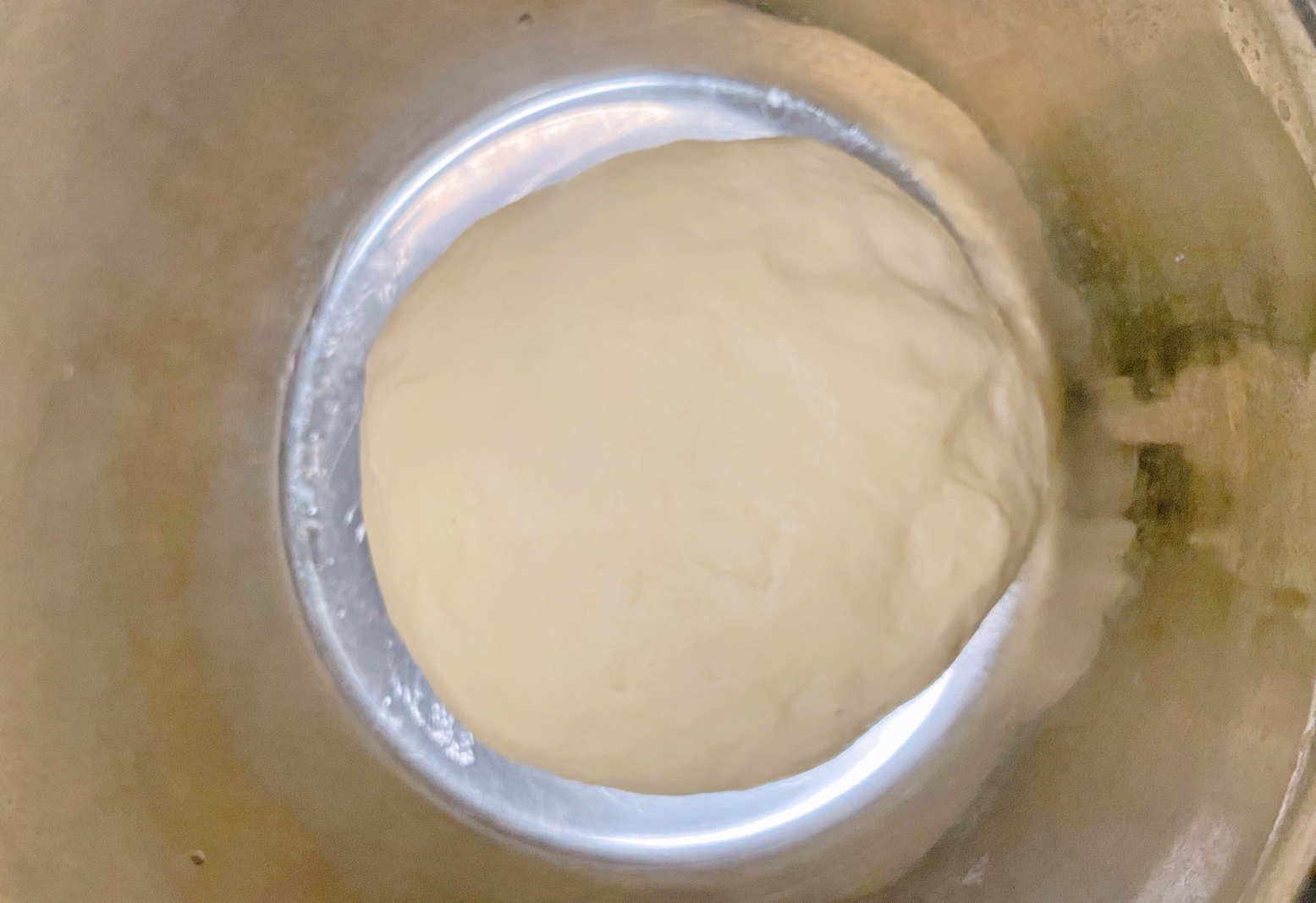 Rest kneaded dough in a container to allow it to rise.