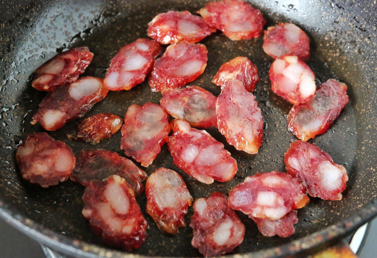 Sauté sausage in pan on low heat to release oil, then set aside.