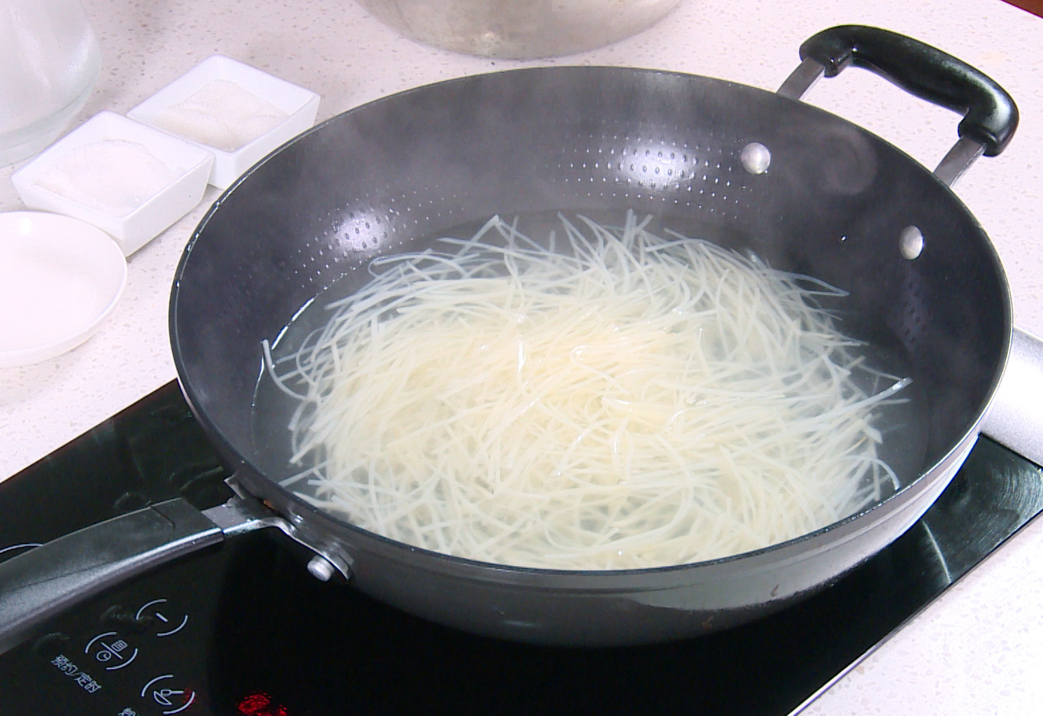 Blanch potato strips in boiling water with salt, then cool in cold water for crispiness.