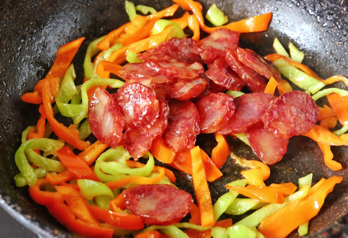 Add sausage back to pan with softened peppers and stir-fry.