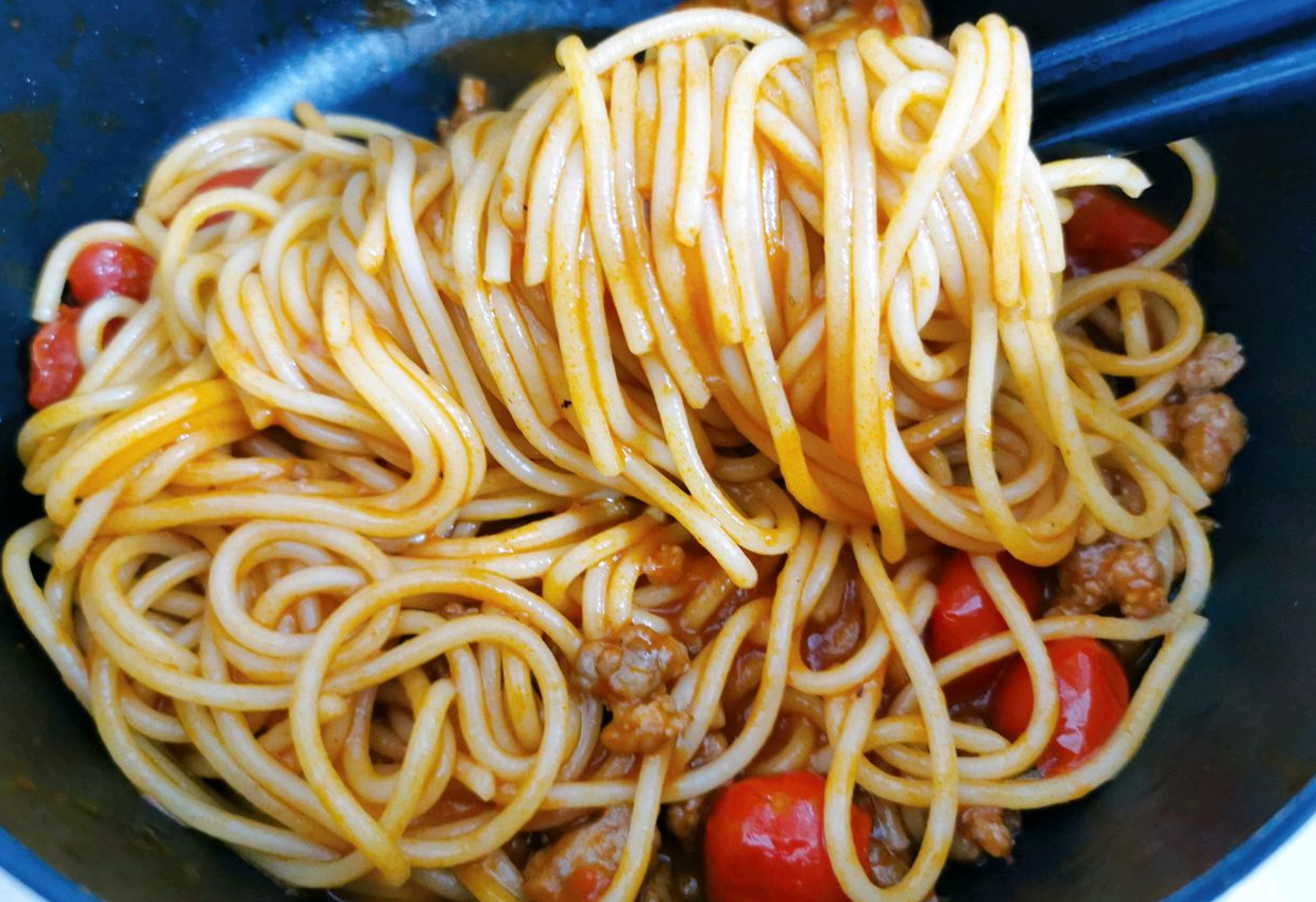 Cooked spaghetti rinsed with cold water, tossed in tomato sauce.