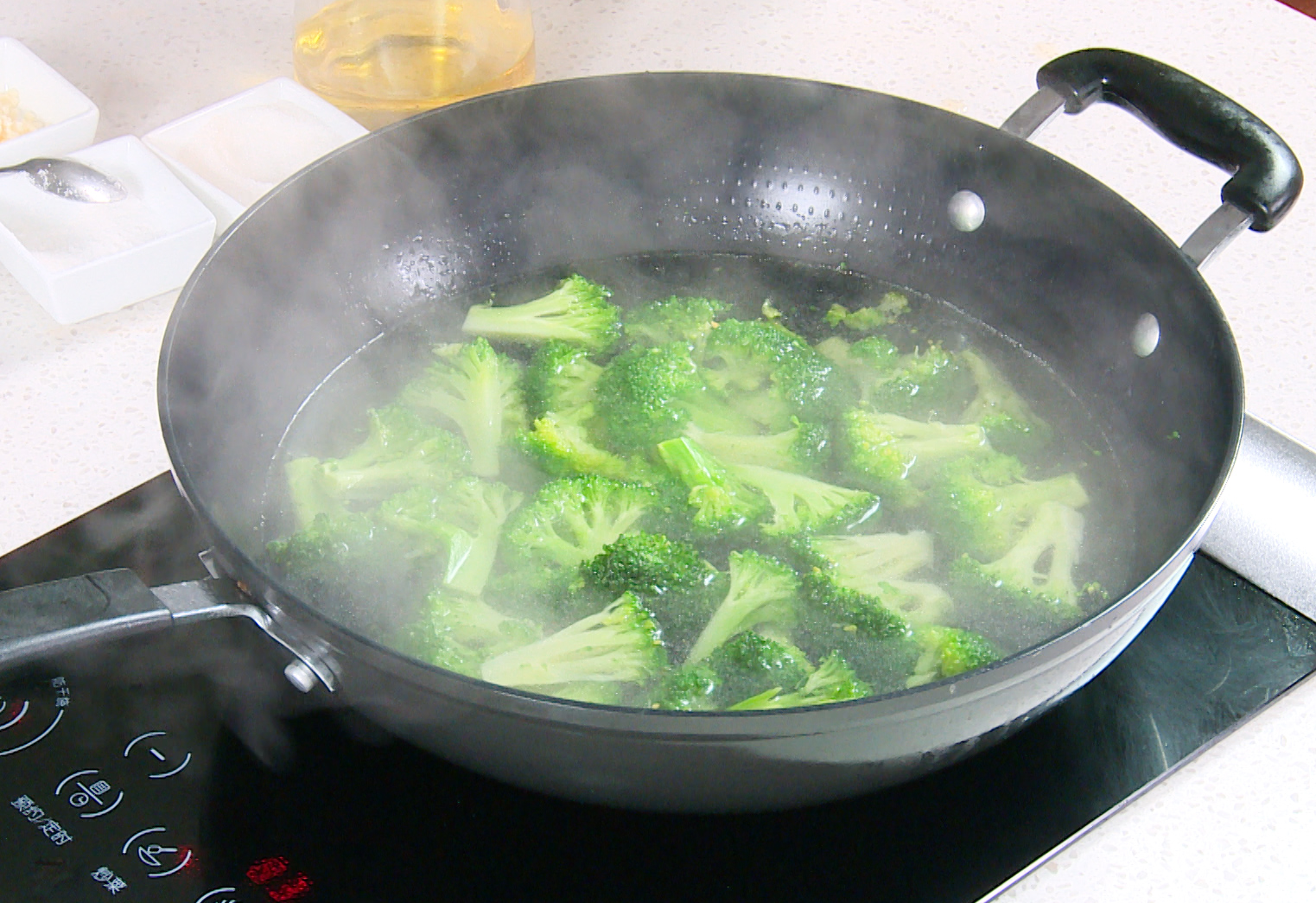 Blanch broccoli by boiling in salted water with oil.