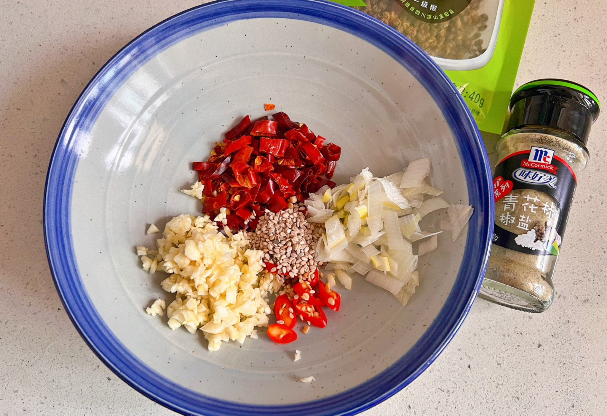 Combine Thai chili peppers, dried chili peppers, garlic, scallions, and sesame seeds in bowl.