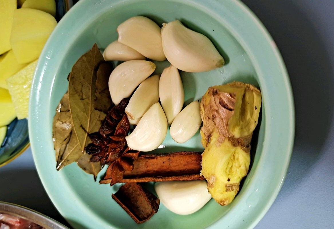 Prep garlic, star anise, cinnamon sticks, bay leaves, and dried chili peppers.