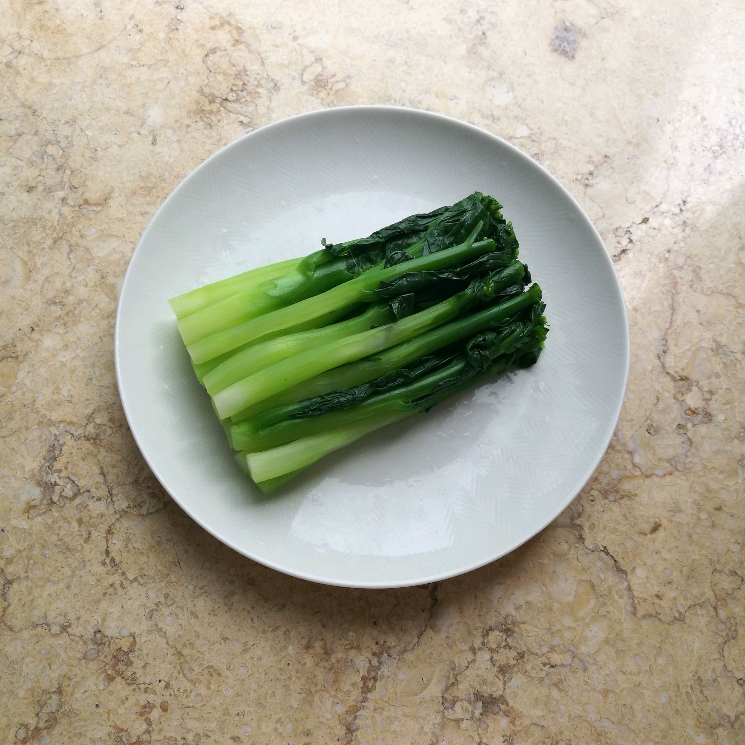 Instructions for preparing and serving cooked Kai-lan on a plate.