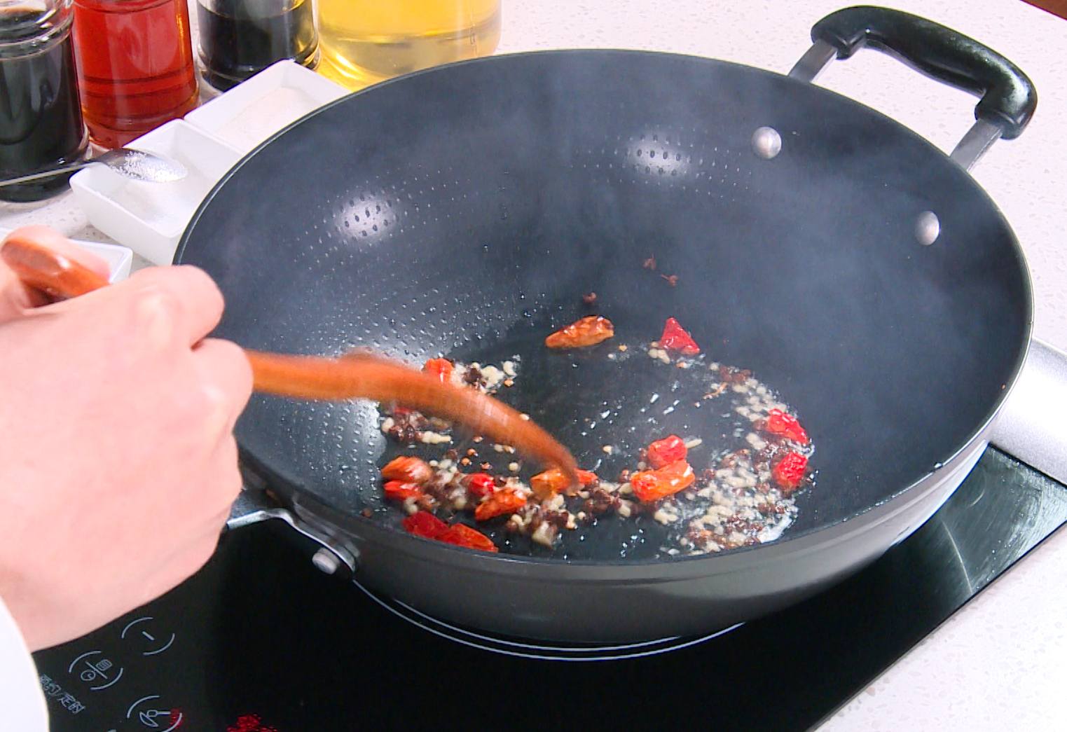 Add aromatics like ginger and chili peppers to stir-fry for flavor. Adjust chilies to desired heat level.