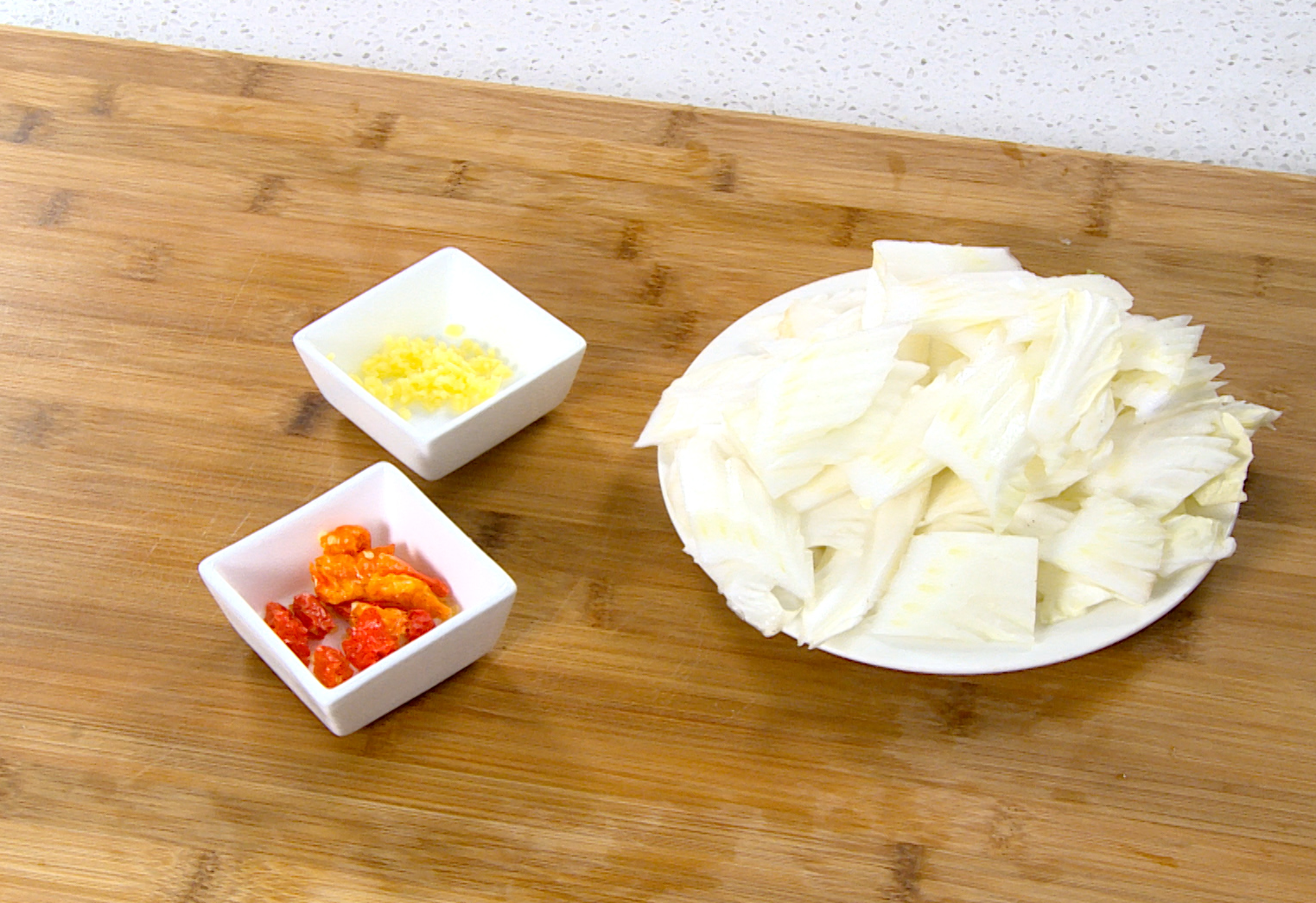 Prep cabbage stems, ginger, dried chilies, and Sichuan peppercorns for a Sichuan dish.