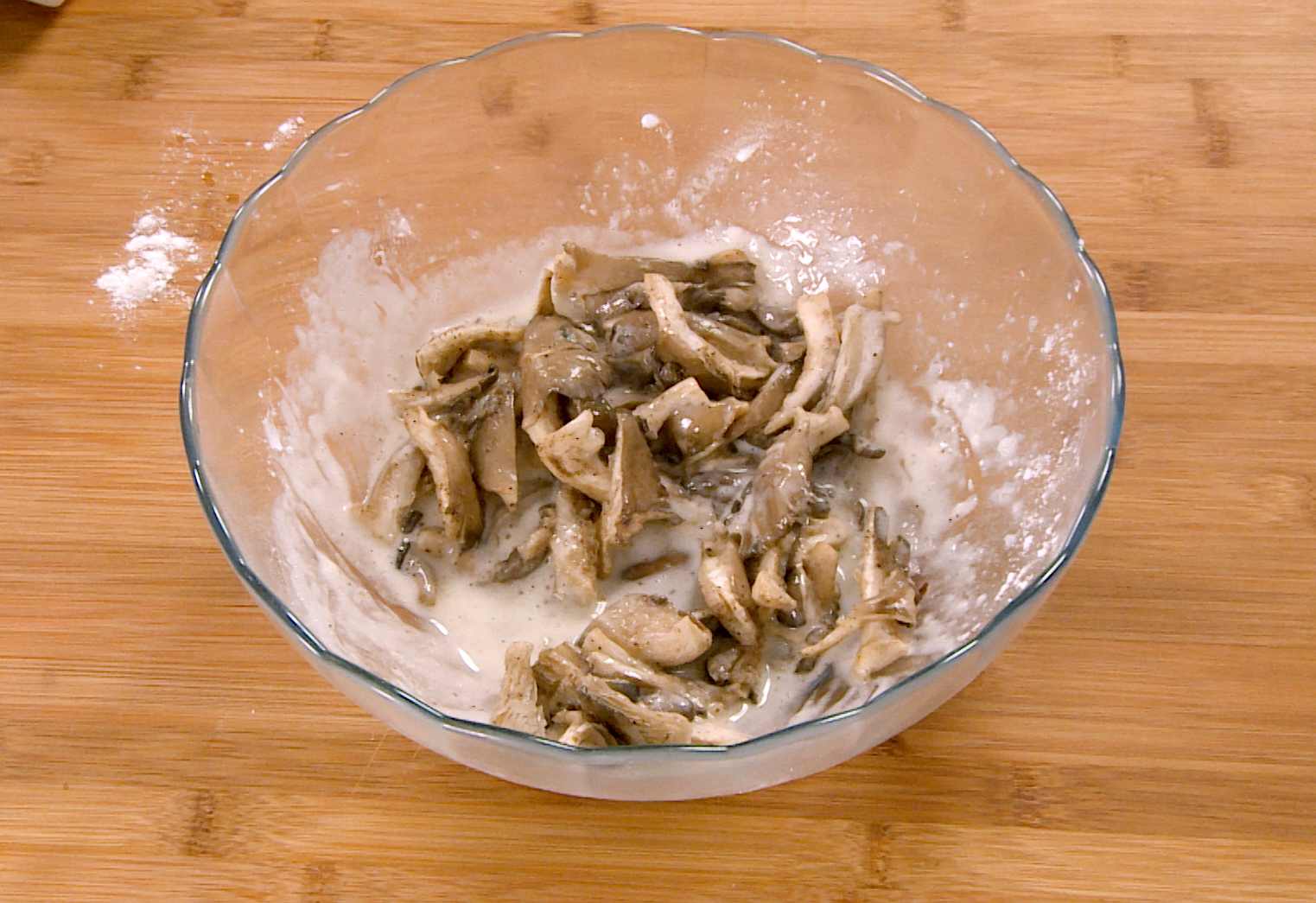 Coat oyster mushrooms with batter for full coverage.