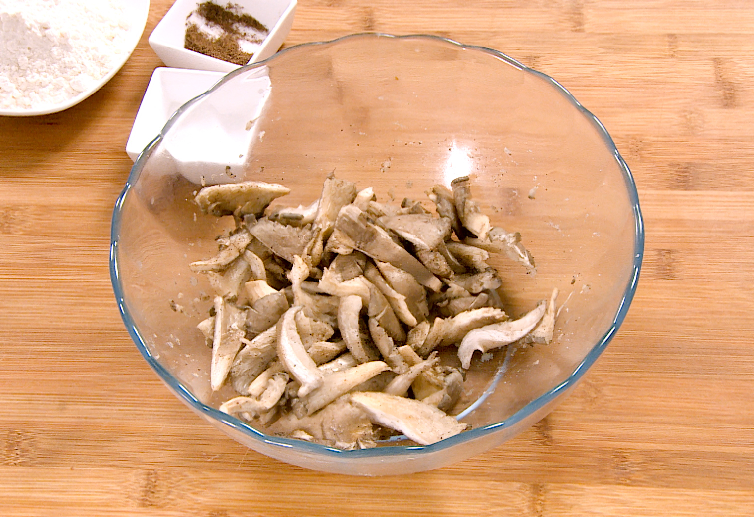 Prepare oyster mushrooms by cutting, seasoning, and marinating for flavor.