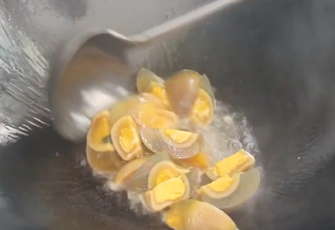 Heat oil in a pot and add the century eggs to fry