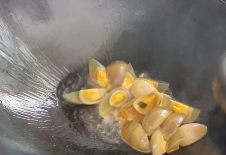 Heat oil in a pot and add the century eggs to fry