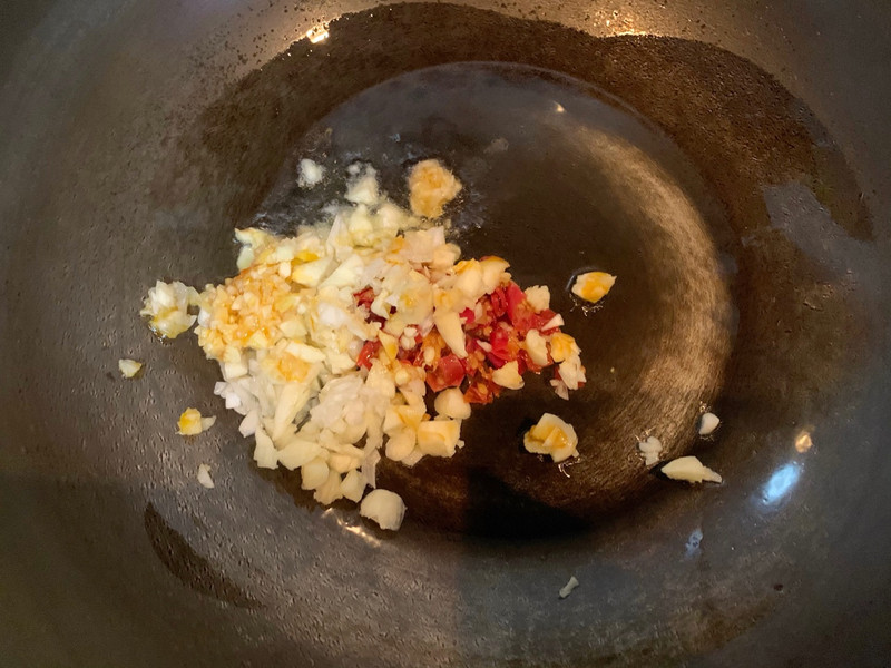 Heat oil in a pan and sauté ginger, garlic, and chopped chili 