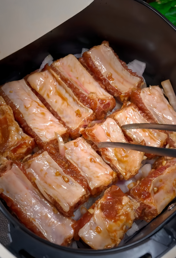 Place the marinated ribs evenly into the air fryer